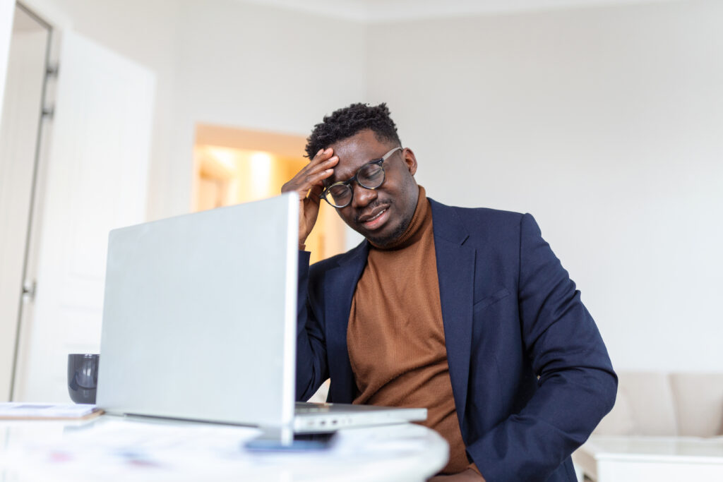 Stressed man after a long day at work attending to customers
